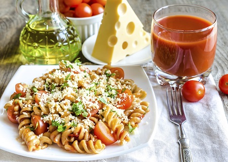 Portion Nudeln mit Kräutern, Tomate und Käse